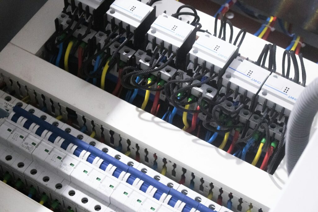 A modern consumer unit with rows of circuit breakers and neatly dressed wiring.