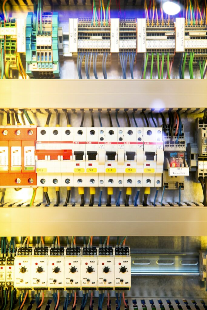 An industrial control panel with rows of breakers and colour-coded wiring.