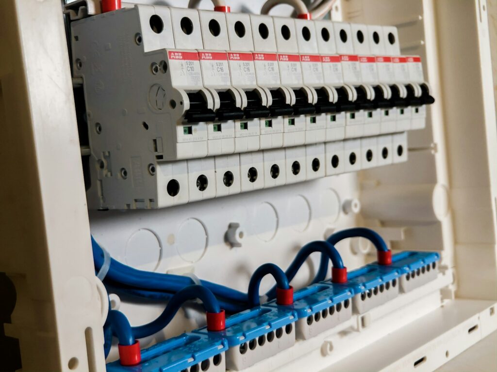 A white domestic consumer unit with its cover removed, showing the breaker bank and neutral bar.
